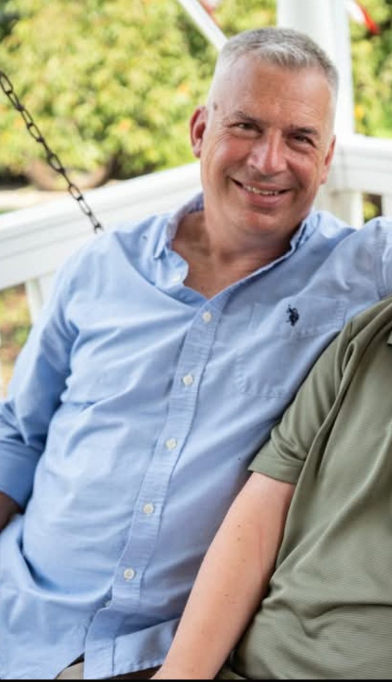 Mike Meredith seated on a porch swing